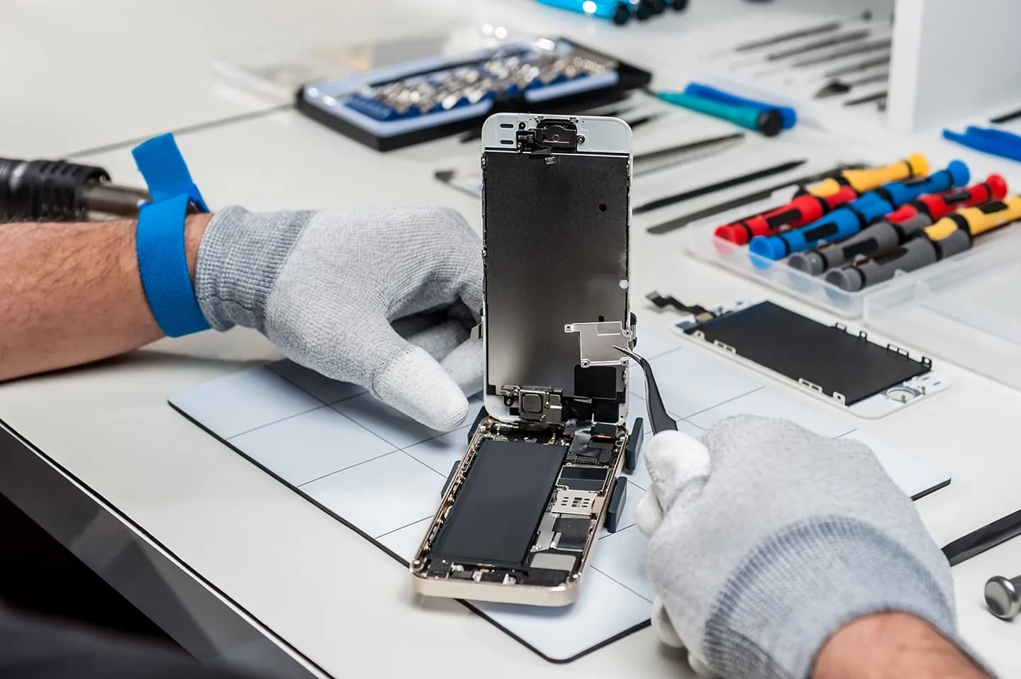 iPhone technician performing repair at professional repair desk